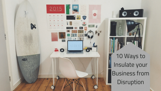 a desk with a surfboard and a laptop on it