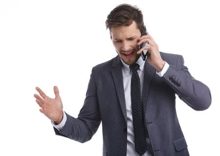 a man in a suit talking on a cell phone