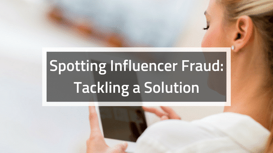 a woman holding up a sign that says spotting influencer fraud tacking a solution