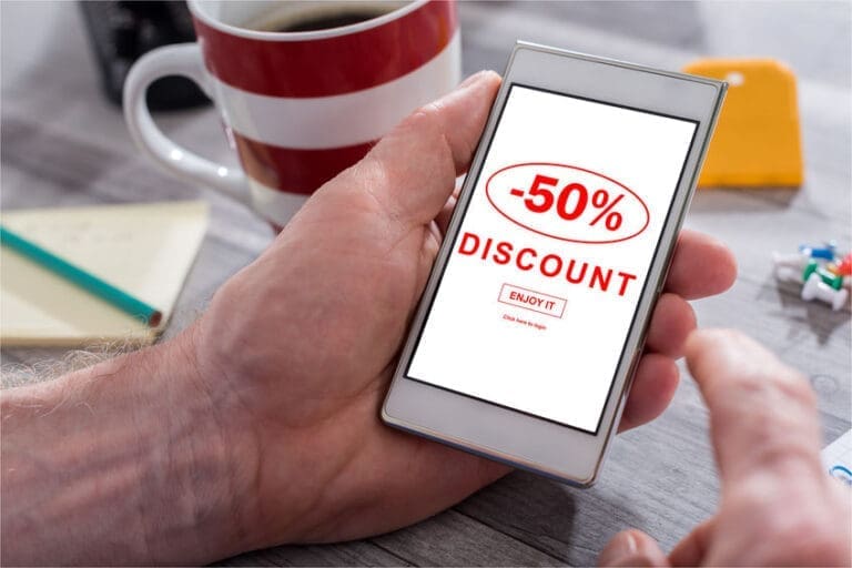a person holding a smart phone with the text 50 % discount on it