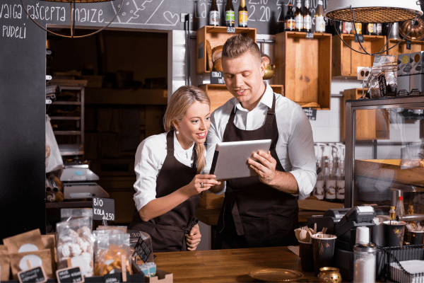 a man and woman are looking at a tablet