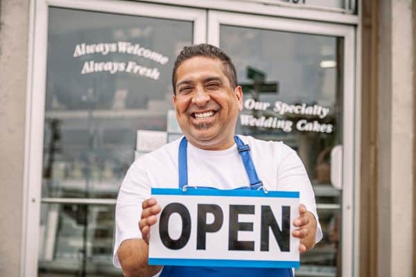 a man holding a sign that says open