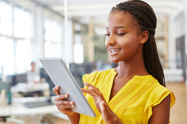 a young girl holding a tablet computer in her hands